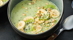 Groene smoothiebowl met kiwi, banaan, kokos en muesli